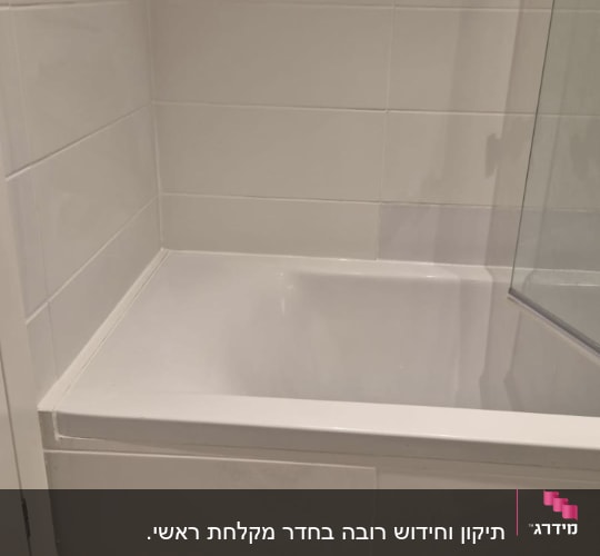 אמבטיה חדשה עם אריחים לבנים וקיר זכוכית